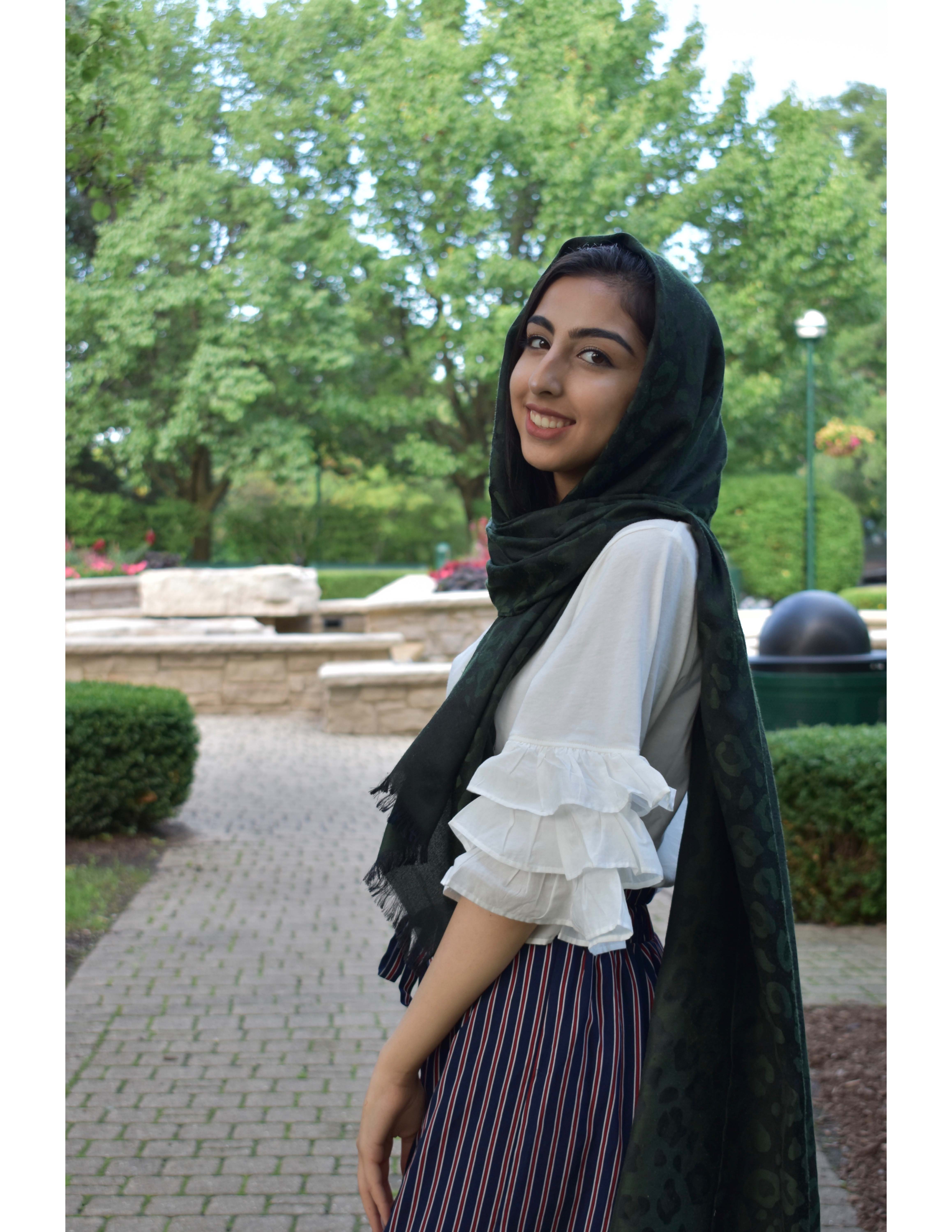 Image of Sumayyah Haider standing on a stone path in front of trees